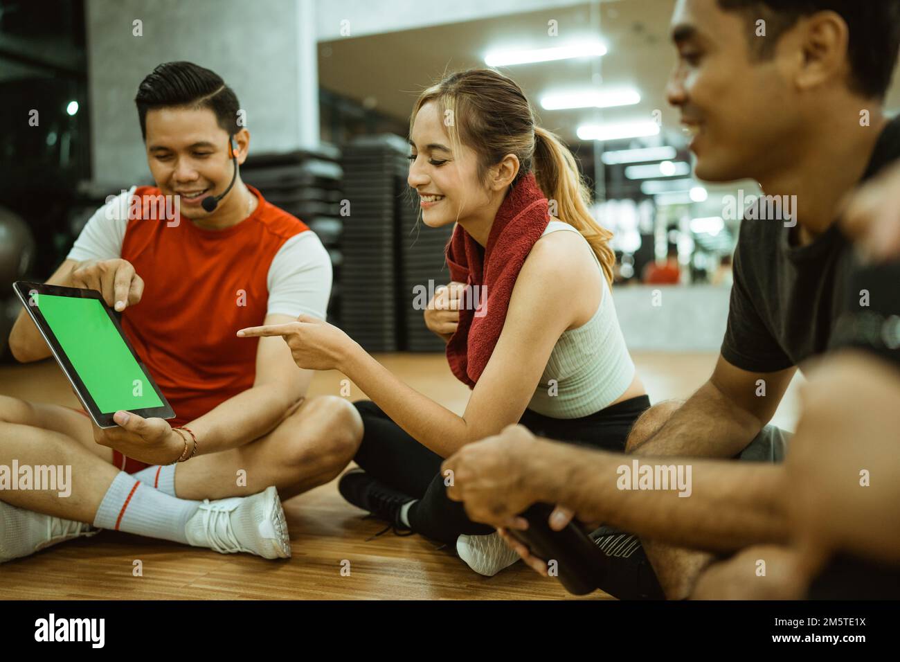 beautiful-woman-pointing-at-screen-while-male-instructor-showing-tablet