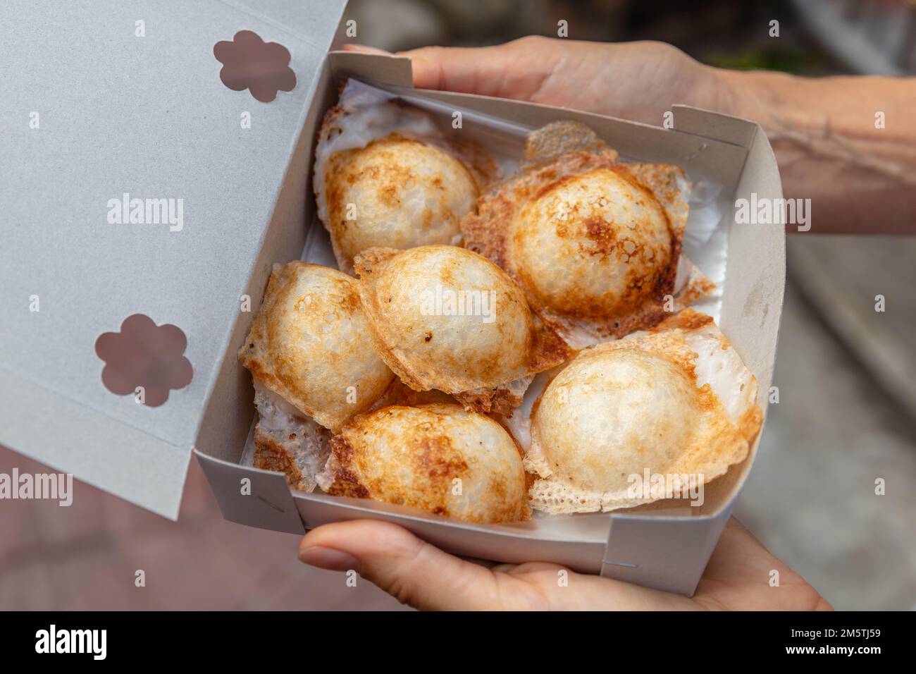 A box of Khanom khrok or coconut-rice pancakes, Thai traditional dessert with coconut milk and rice flower. National cuisine of Thailand. Stock Photo