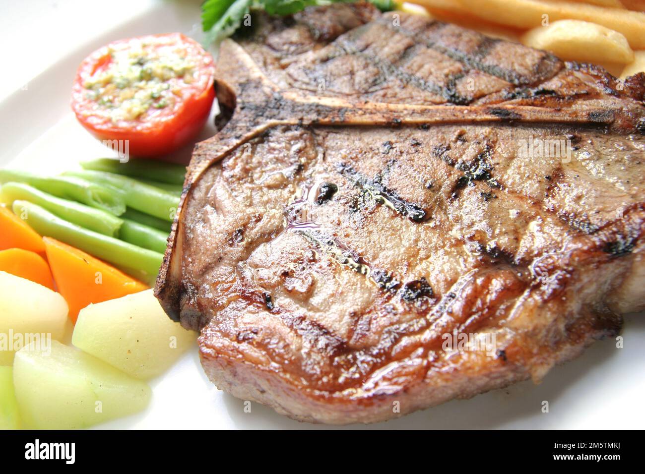 delicious grilled Tbone steak barbecue portion with frenchfries on