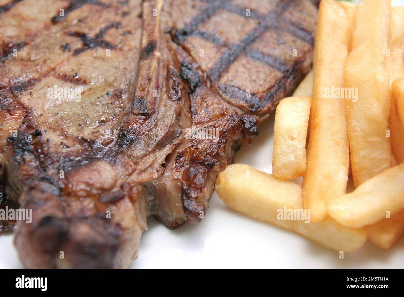 delicious grilled Tbone steak barbecue portion with frenchfries on
