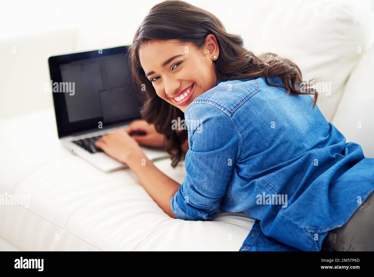 Blogging is great. a young woman browsing the web on her laptop at home. Stock Photo