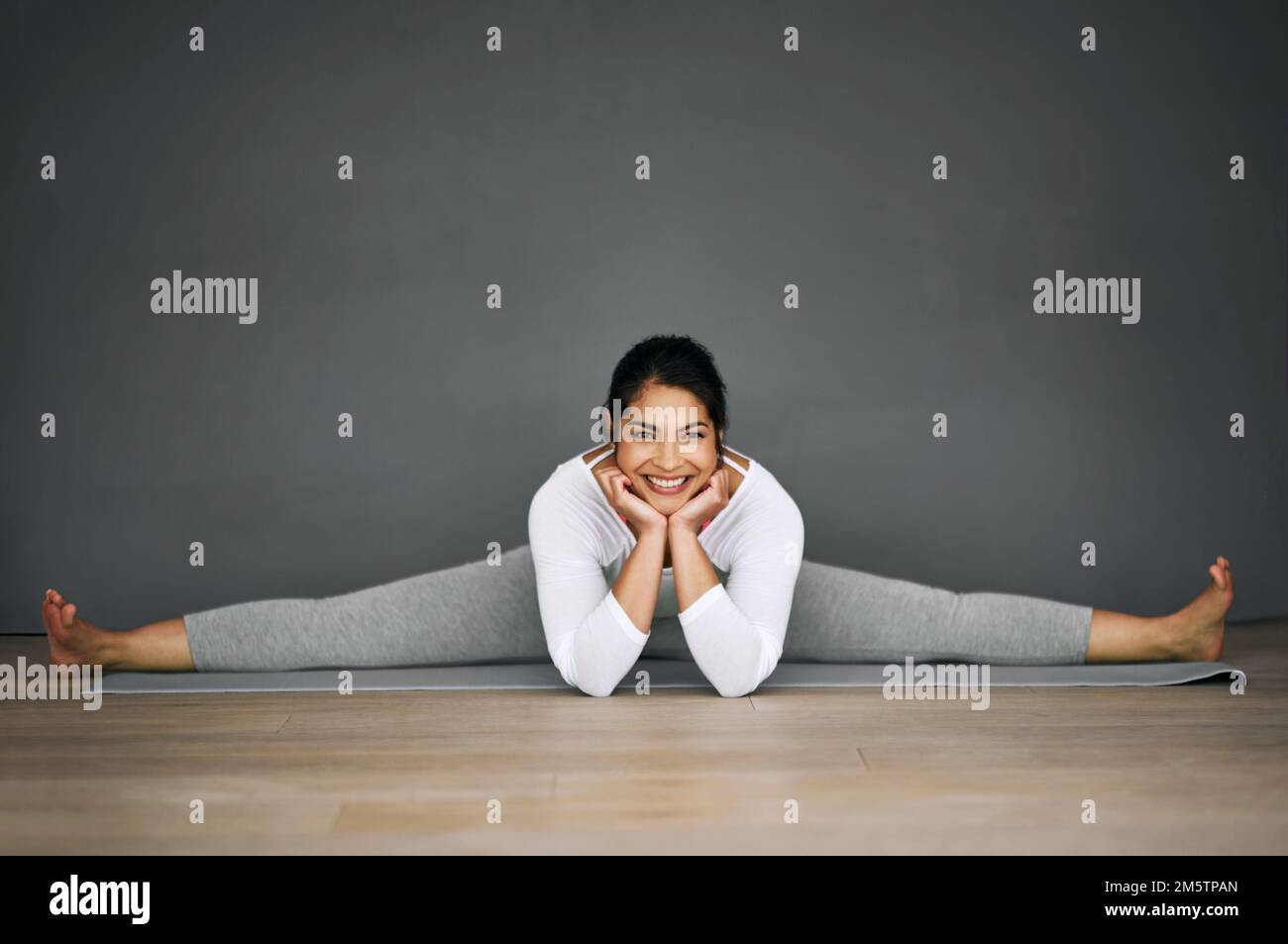 Woman doing yoga frontal split stretch Stock Photo by Photology75