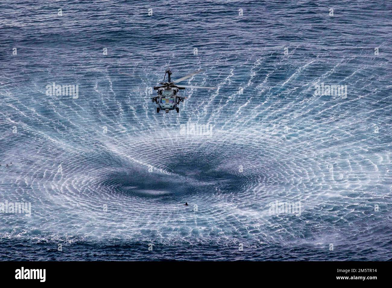At Sea. 13th Dec, 2022. Sailors assigned to Explosive Ordnance Disposal Mobile Unit 12, jump from an MH-60S Nighthawk helicopter, attached to Helicopter Sea Combat Squadron (HSC) 5, December. 13, 2022. Navy EOD operate as part of Navy Expeditionary Combat Command and are experts in countering explosive hazards in all environments by being able to locate, identify, render safe, recover, conduct field evaluation, and dispose of all explosive ordnance. The George H.W. Bush Carrier Strike Group (CSG) is comprised of George H.W. Bush, Carrier Air Wing (CVW) 7, Destroyer Squadron 26, the Inform Stock Photo