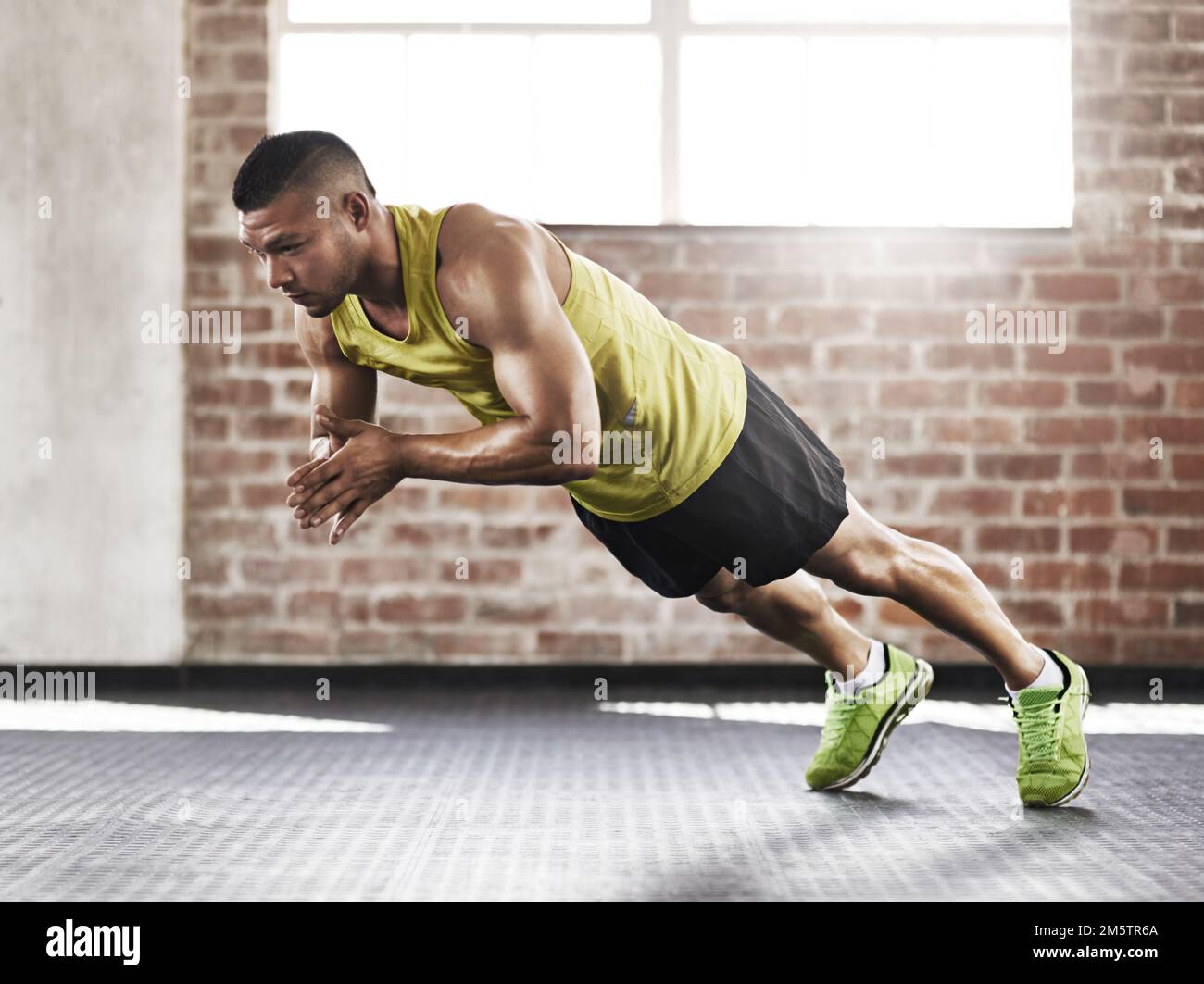 The front clap pushup. Full length shot of a young man working out in the gym. Stock Photo