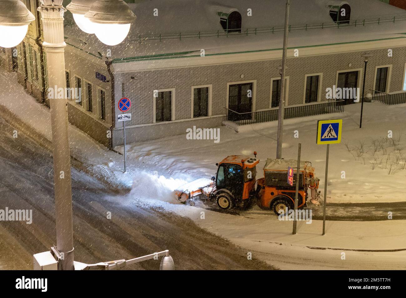 Moscow, Russia - December 7, 2022: Snowplow clearing snow from the street. Multihog mxc 100 Bucher Gmeiner Husky BlueDynamics Stock Photo