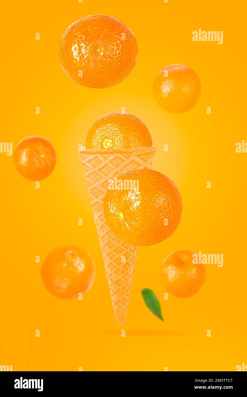 Falling ice cream cone with mandarin fruits. Seven flying whole