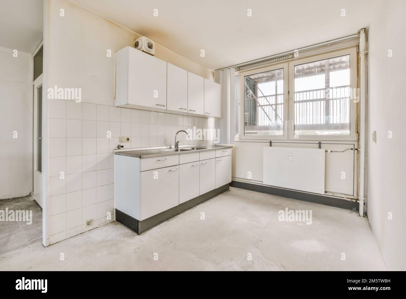 an empty kitchen with white cabinets and appliances in the middle of ...