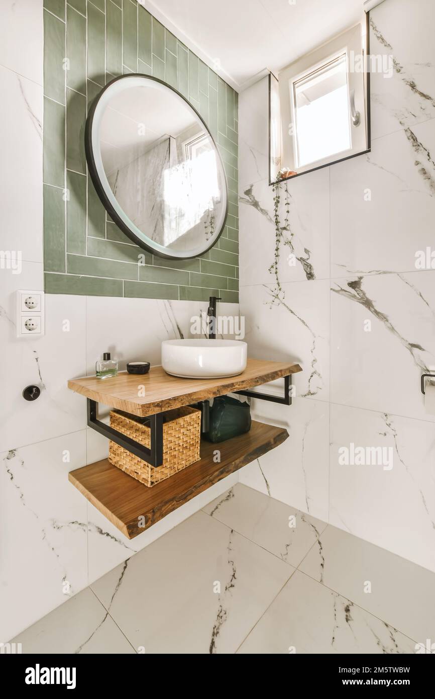 a modern bathroom with marble tiles and green tile walls, including a
