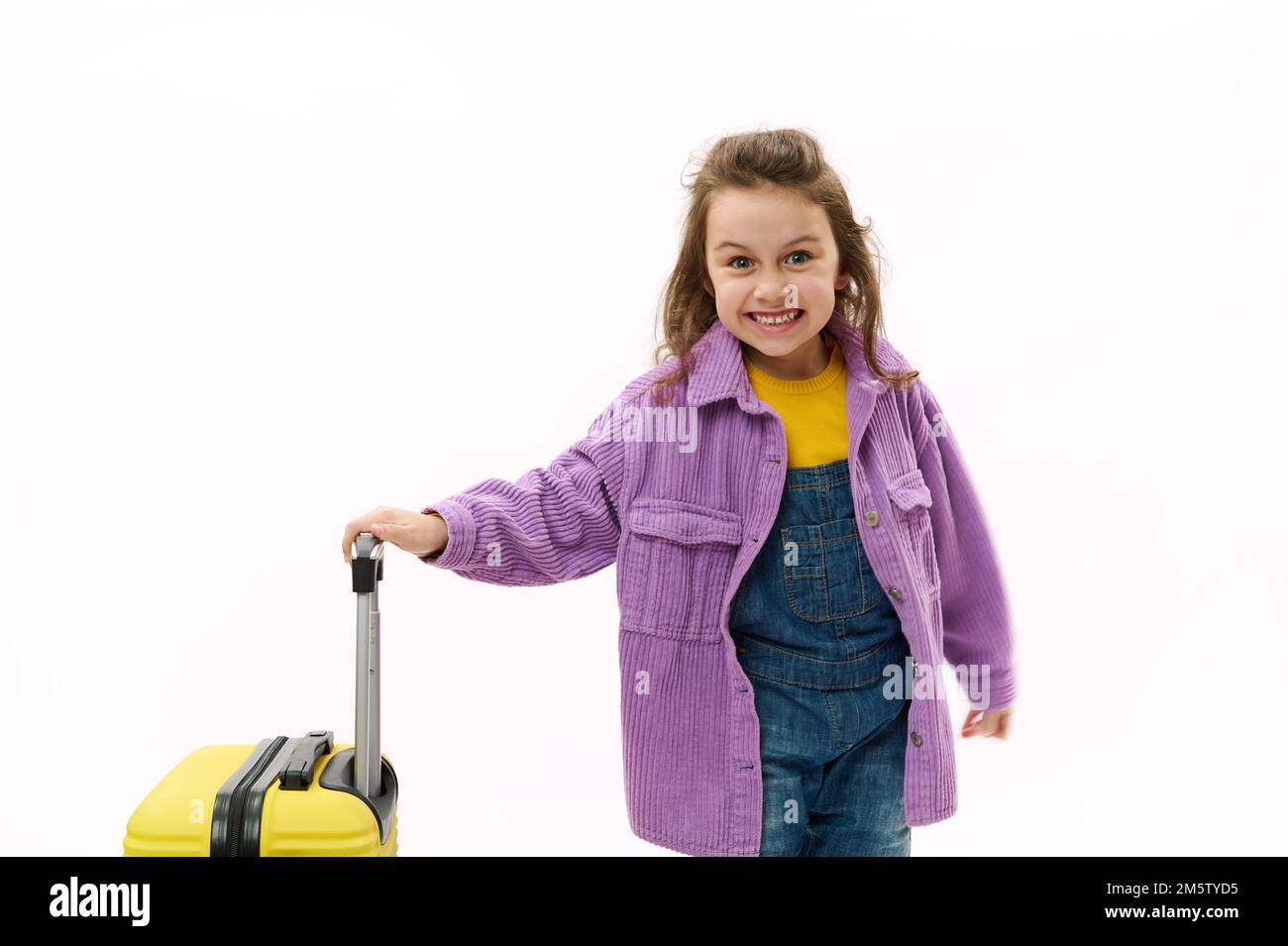 Mischievous traveler child, little girl going for holidays, posing with