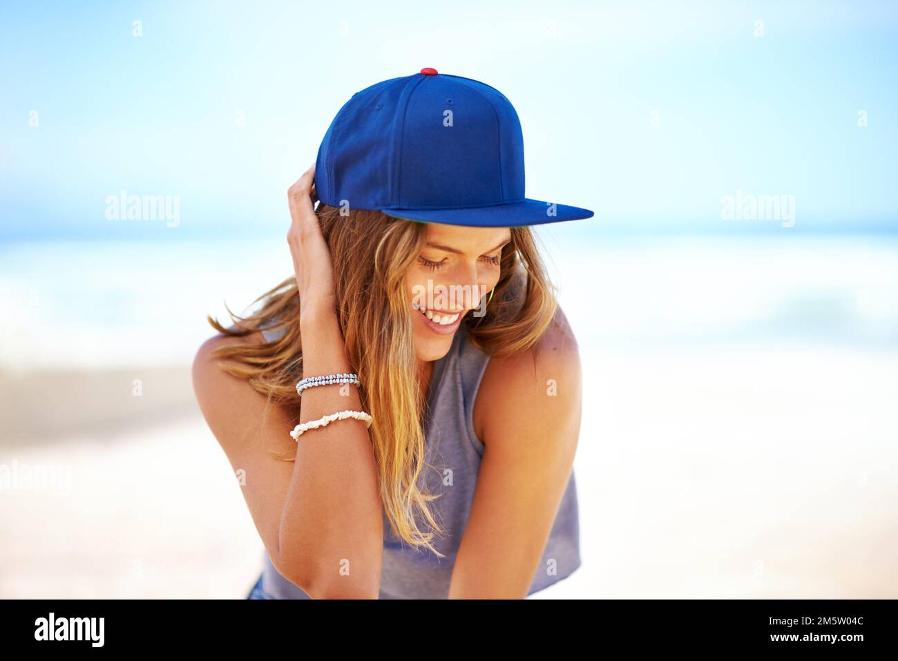 She follows the latest summer fashion. an attractive young woman at the beach. Stock Photo