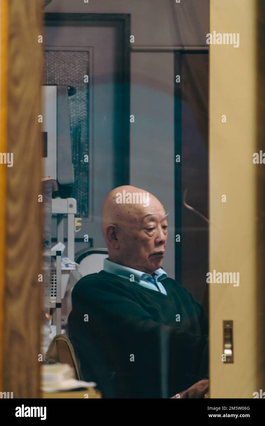 An elderly man sitting in an office Stock Photo