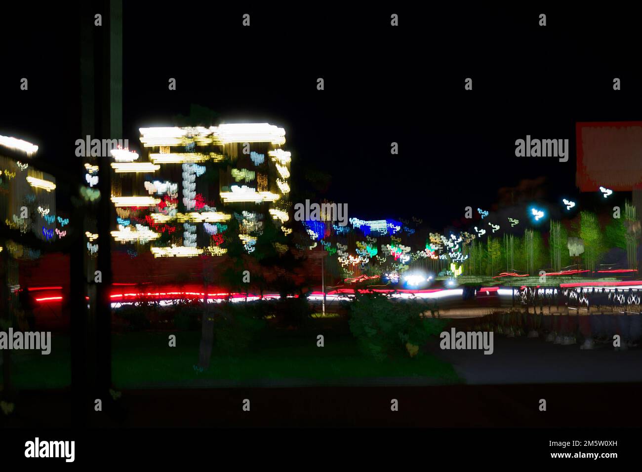 Night city. Photo with motion blur effect. Modern residential multi-storey house with illumination. urban infrastructure. Glow-in-the-Dark Luxury Residential Complex Beautiful Background.. Stock Photo