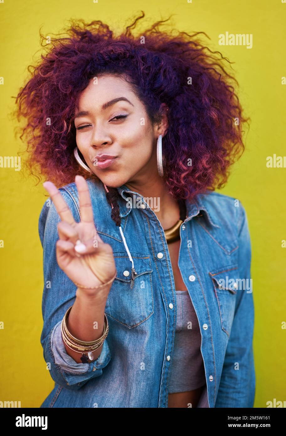 Keepin it real. an attractive young woman showing the peace sign. Stock Photo