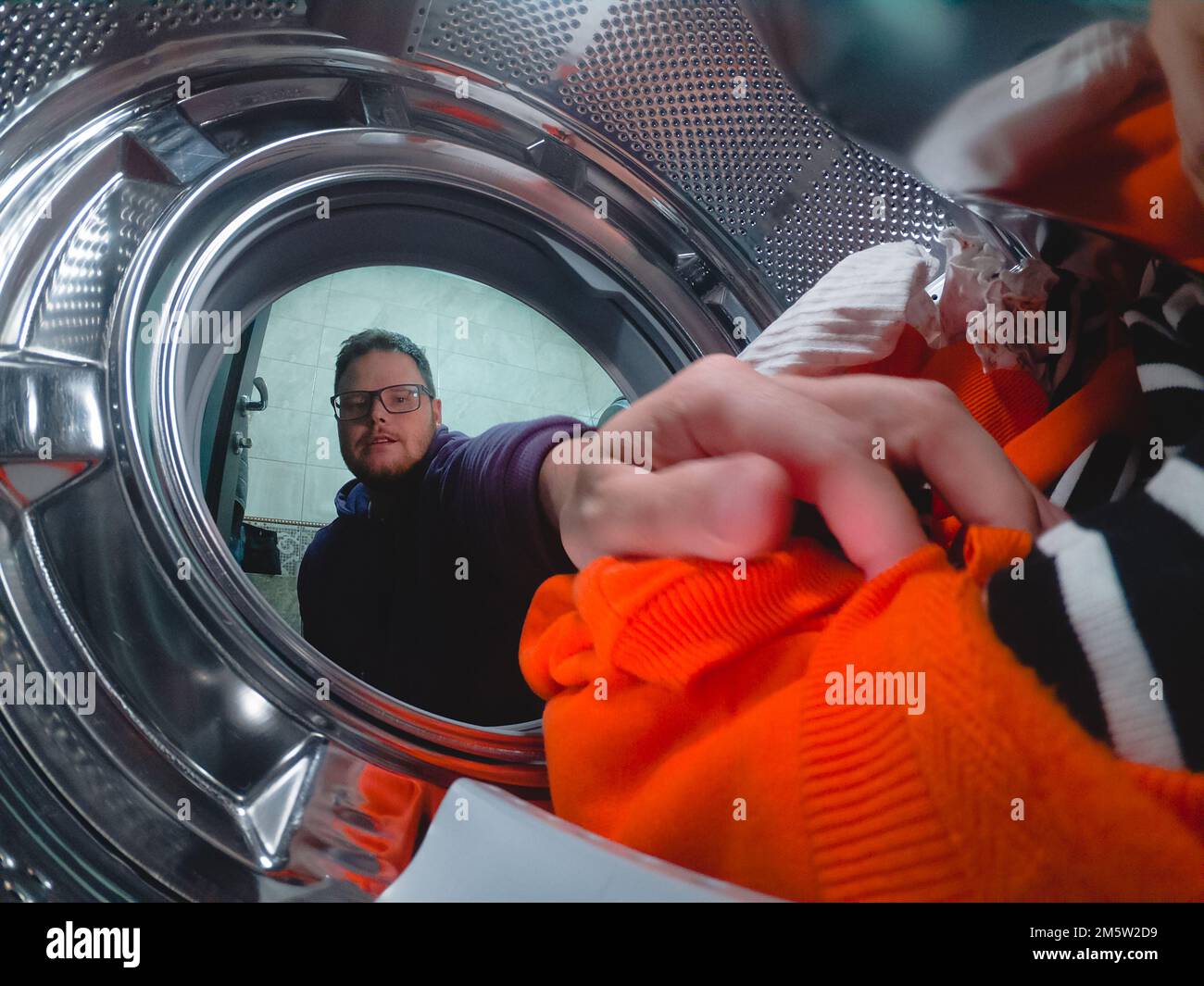 a man puts dirty clothes in the washing machine Stock Photo - Alamy