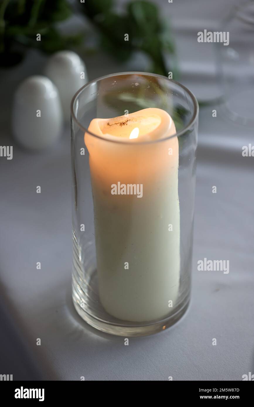 Lit candle pictured in a glass vase in a hotel in London, UK Stock