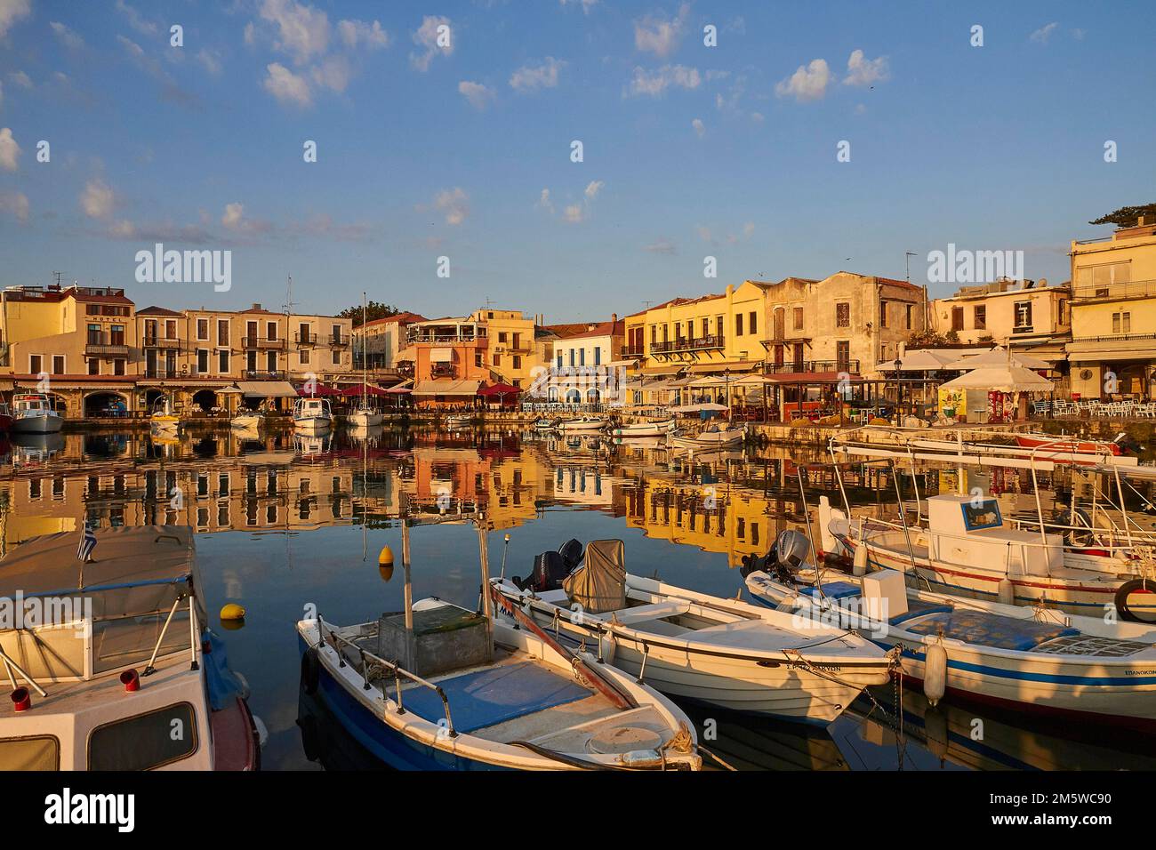 Morning light, sunrise, Venetian harbour, row of houses, colourful houses, blue sky, few grey-white clouds, Rethimnon, Central Crete, island of Stock Photo