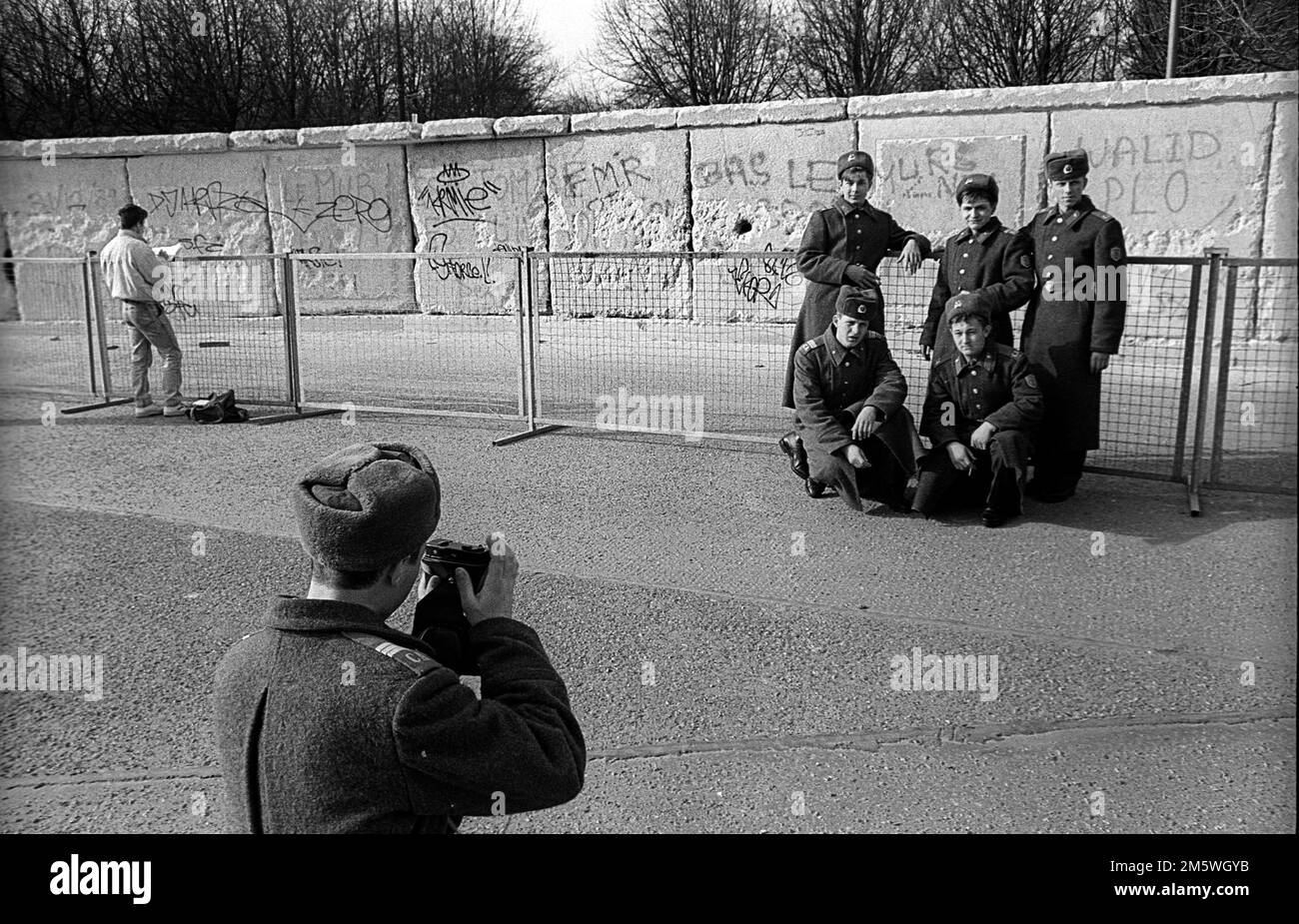 GDR, Berlin, 23. 02. 1990, Soviet (Russian) soldiers taking photos of themselves at the Wall at the Brandenburg Gate Stock Photo