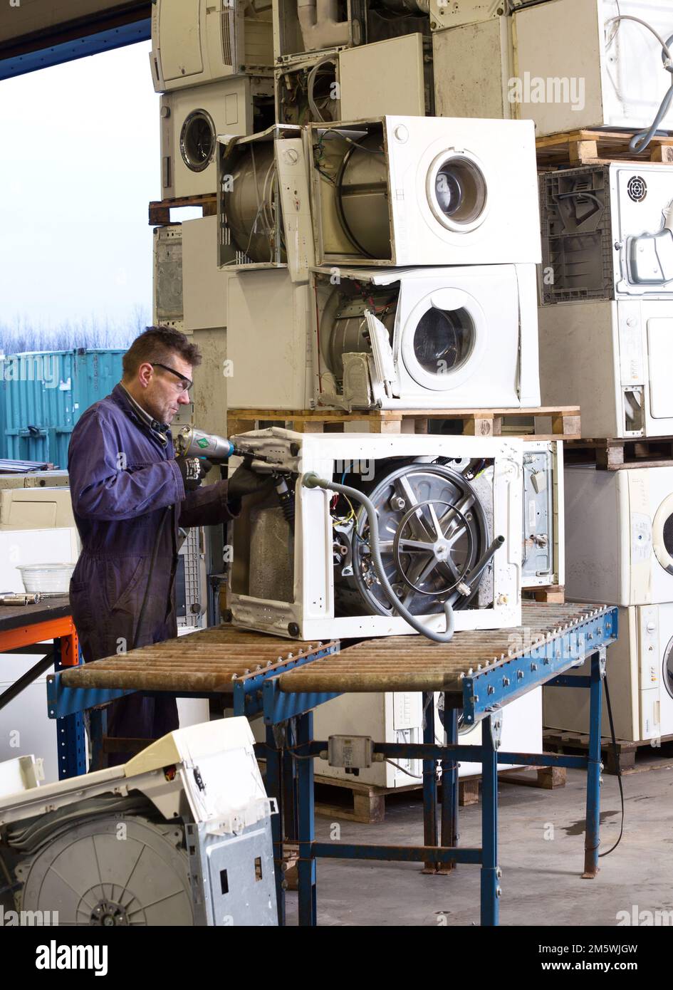 Ewaste. Workplace Road2work, A mechanic disassembles a washing machine