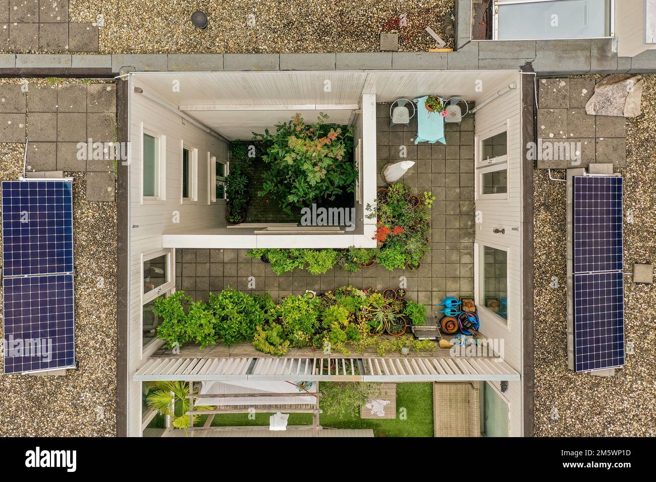an aerial view of a house with solar panels on the roof and some plants