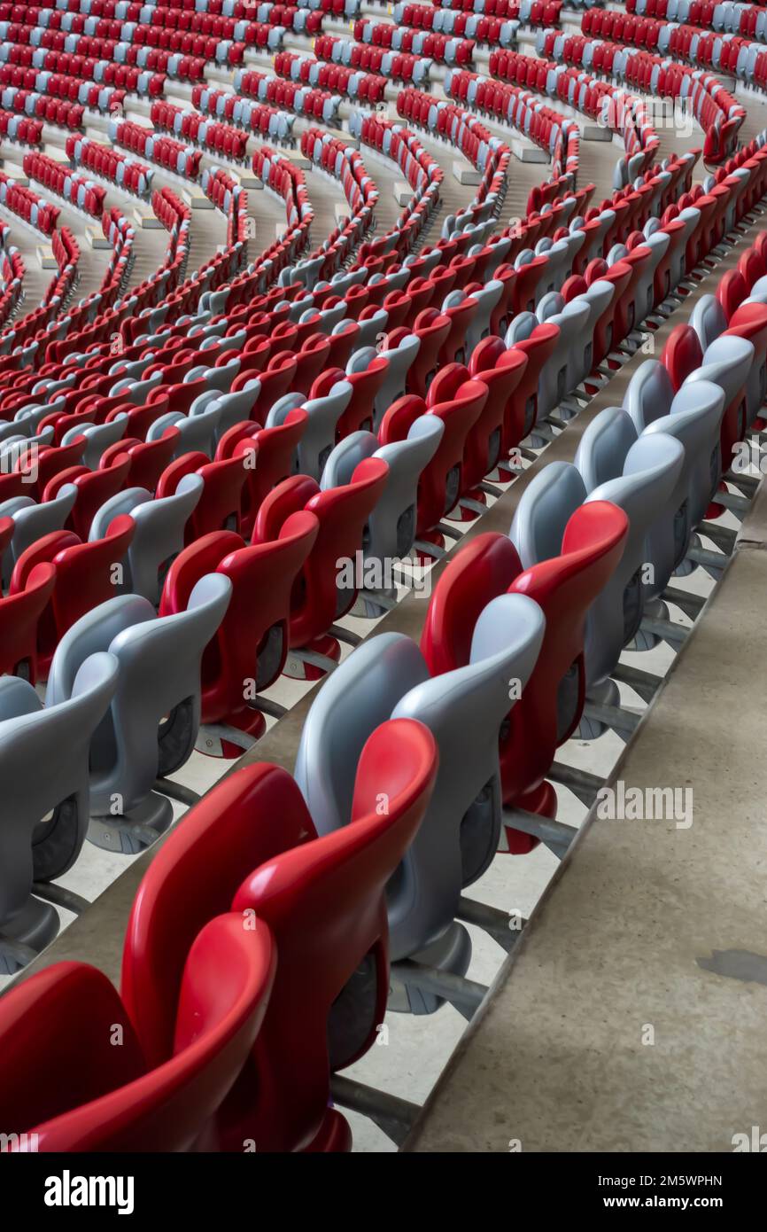 Rows of empty white and red chairs in a football stadium. Anticipation