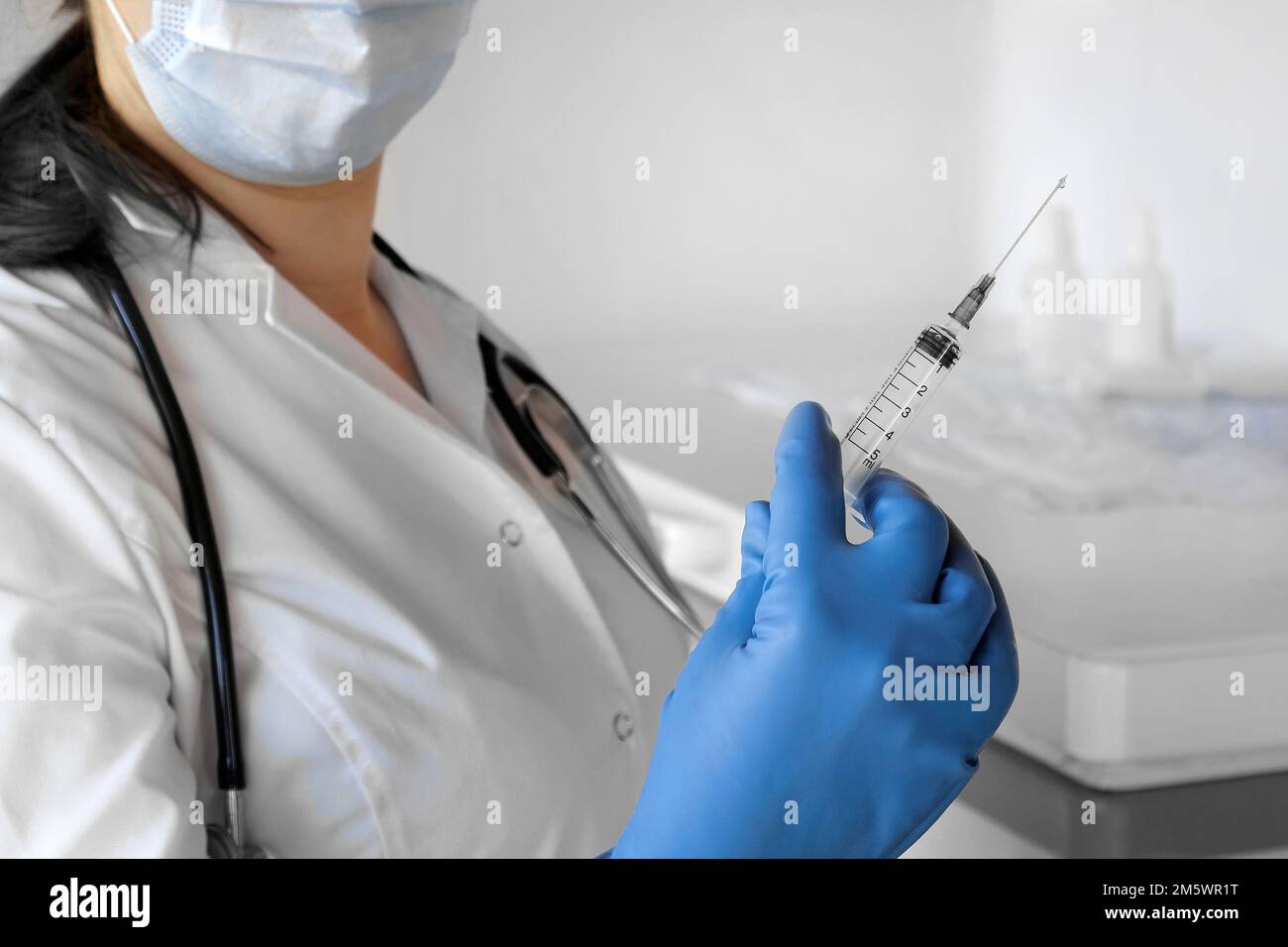 Nurse pushing air out of syringe for vaccine injection. Doctor wearing