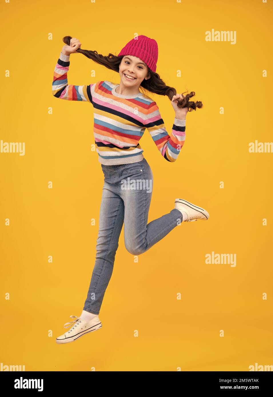 Modern teenage girl 12, 13, 14 year old wearing sweater and knitted hat