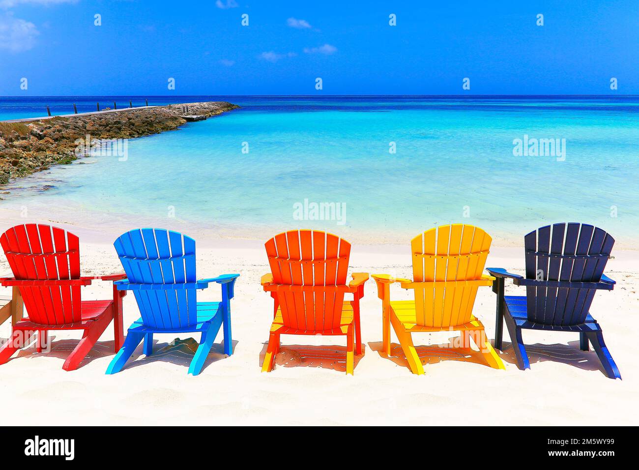 Colorful wooden chairs on white sand beach in Aruba, Duth Caribbean