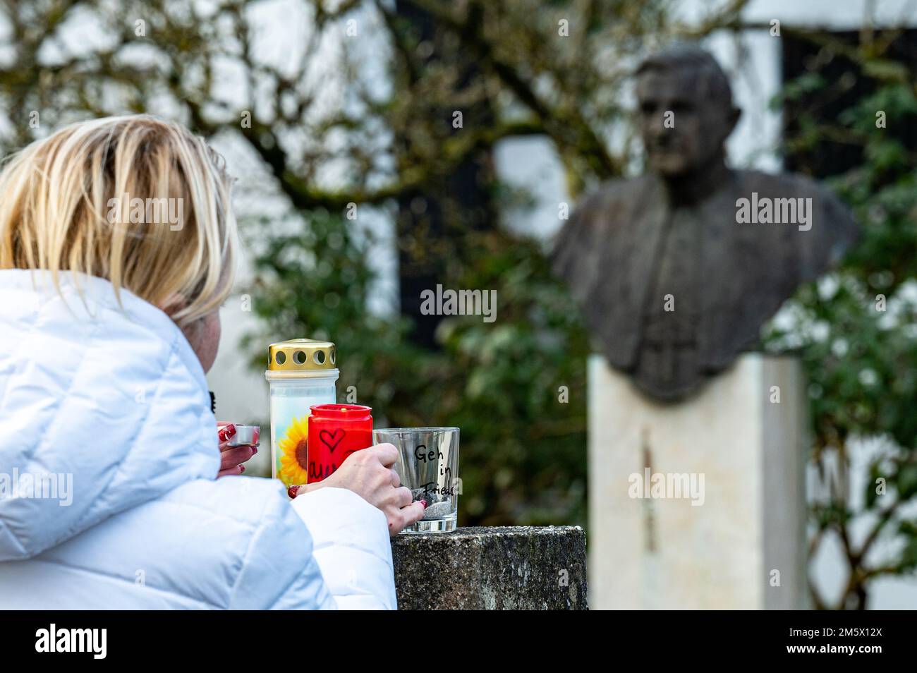 pentling-germany-31st-dec-2022-a-woman-places-a-candle-in-front-of