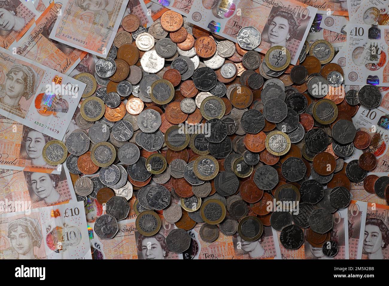£10 bank notes & a pile of British coins including denominations of1p,2p,5p,10p,20p,50p pieces & £1 & £2 coins Stock Photo
