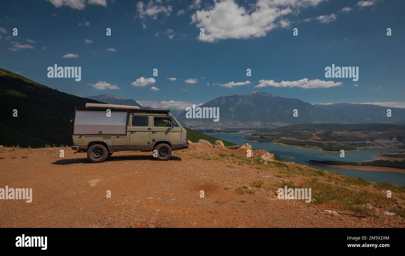 Adventure oldtimer van or camper, campervan on high plain with good view panorama of city Kukes in albania on a summer day. Albanian roadtrip with vin Stock Photo