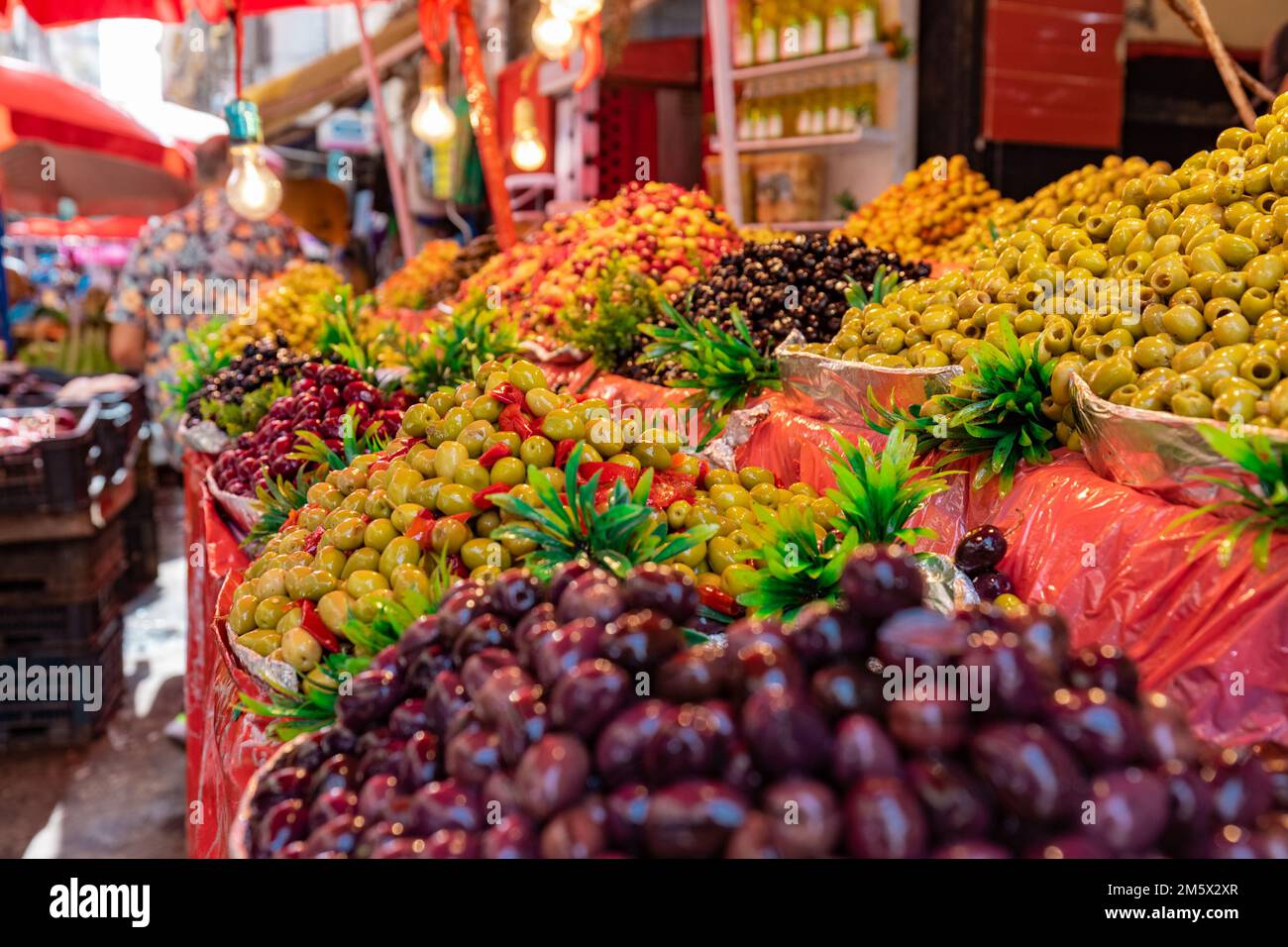 A lot of different olives on display at a public market. Tasty juicy olives on a market stall. Stock Photo