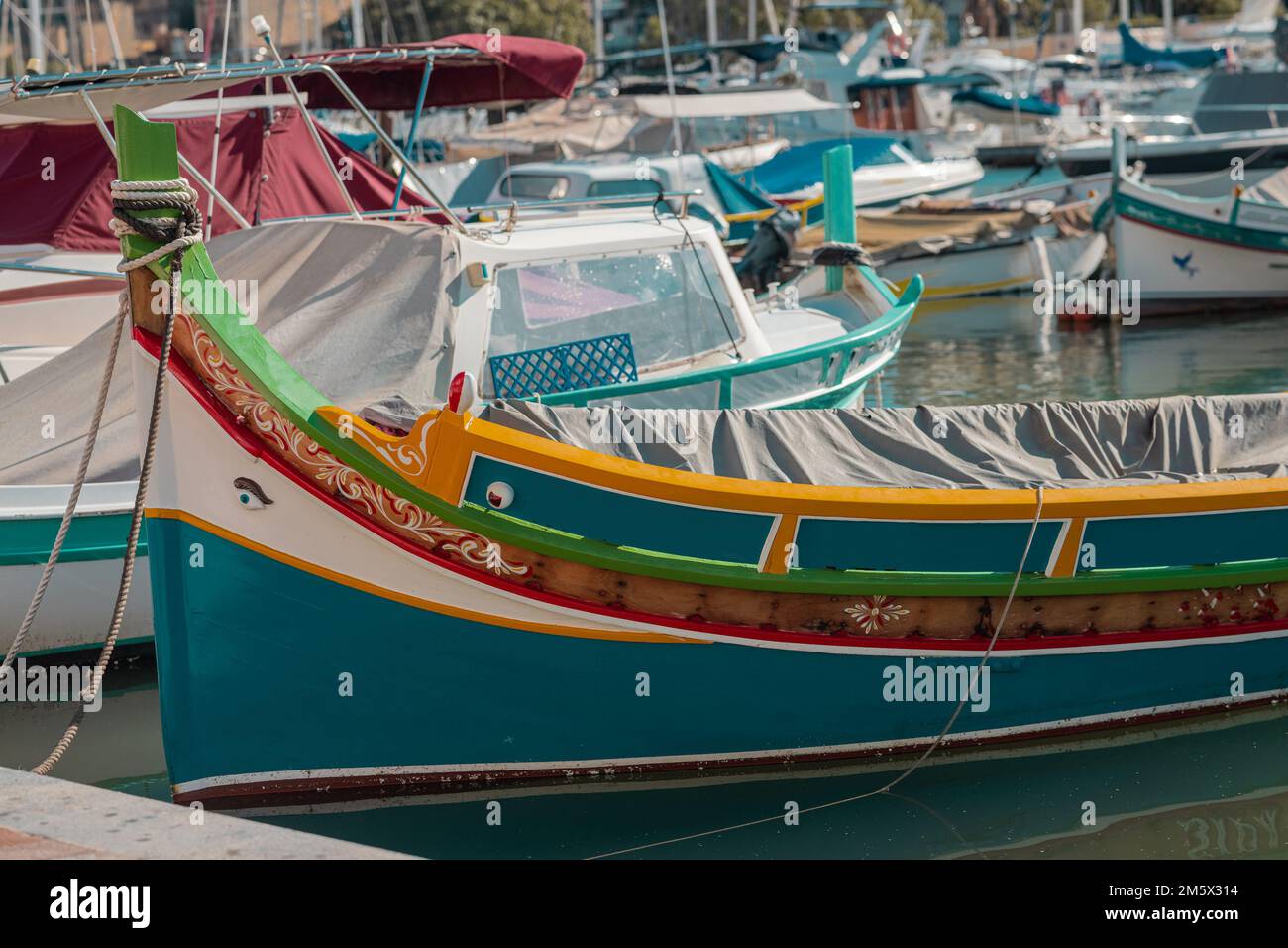 Luzzu, a typical boat of Malta moored in the marina of Valletta on a summer day. Detail of the bow of the boat. Stock Photo