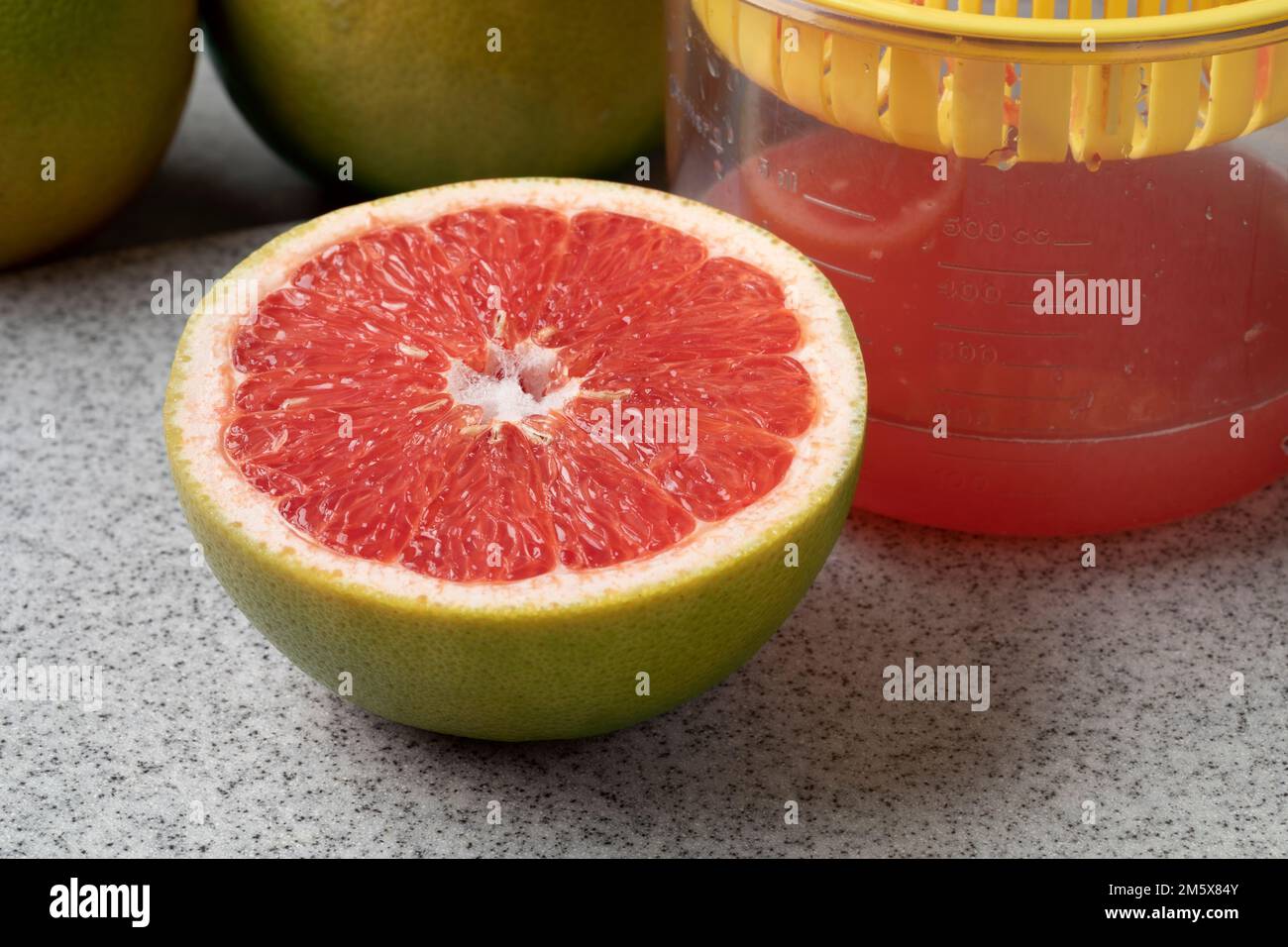 Halved red grapefruit and fresh pressed juice close up Stock Photo