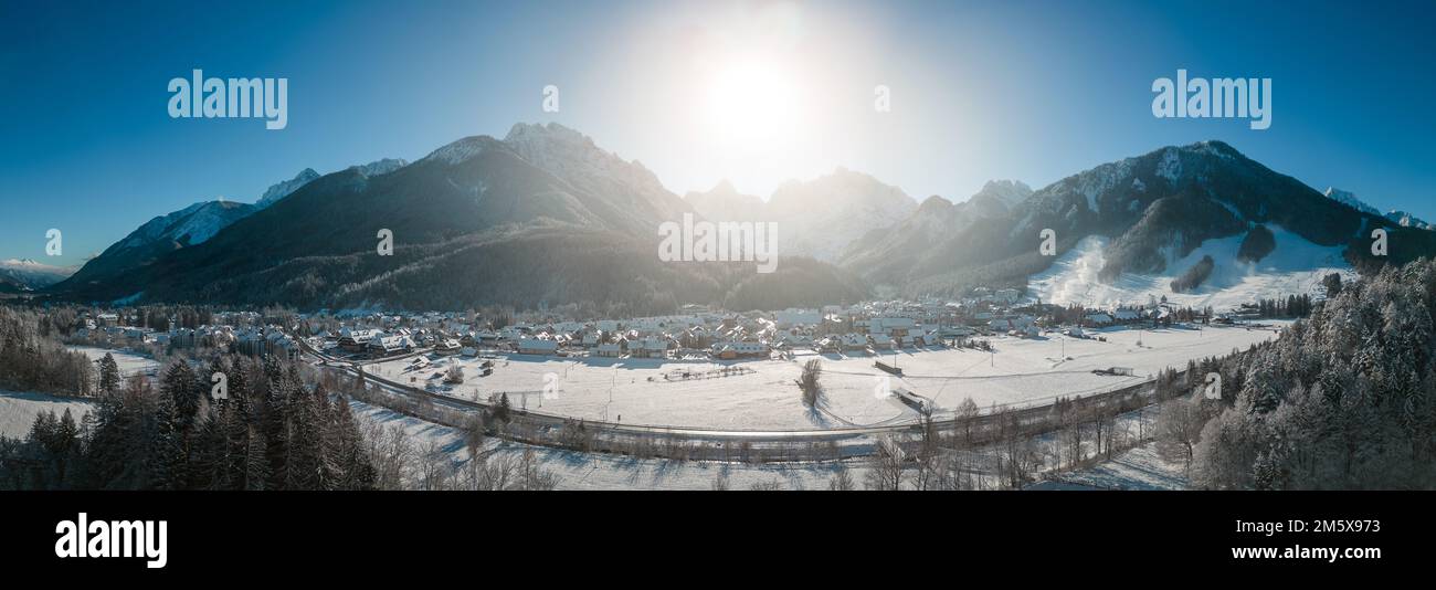 Kranjska Gora in Slovenia covered in snow at winter with Julian Alps and Triglav National Park in the background. Aerial Panorama Stock Photo