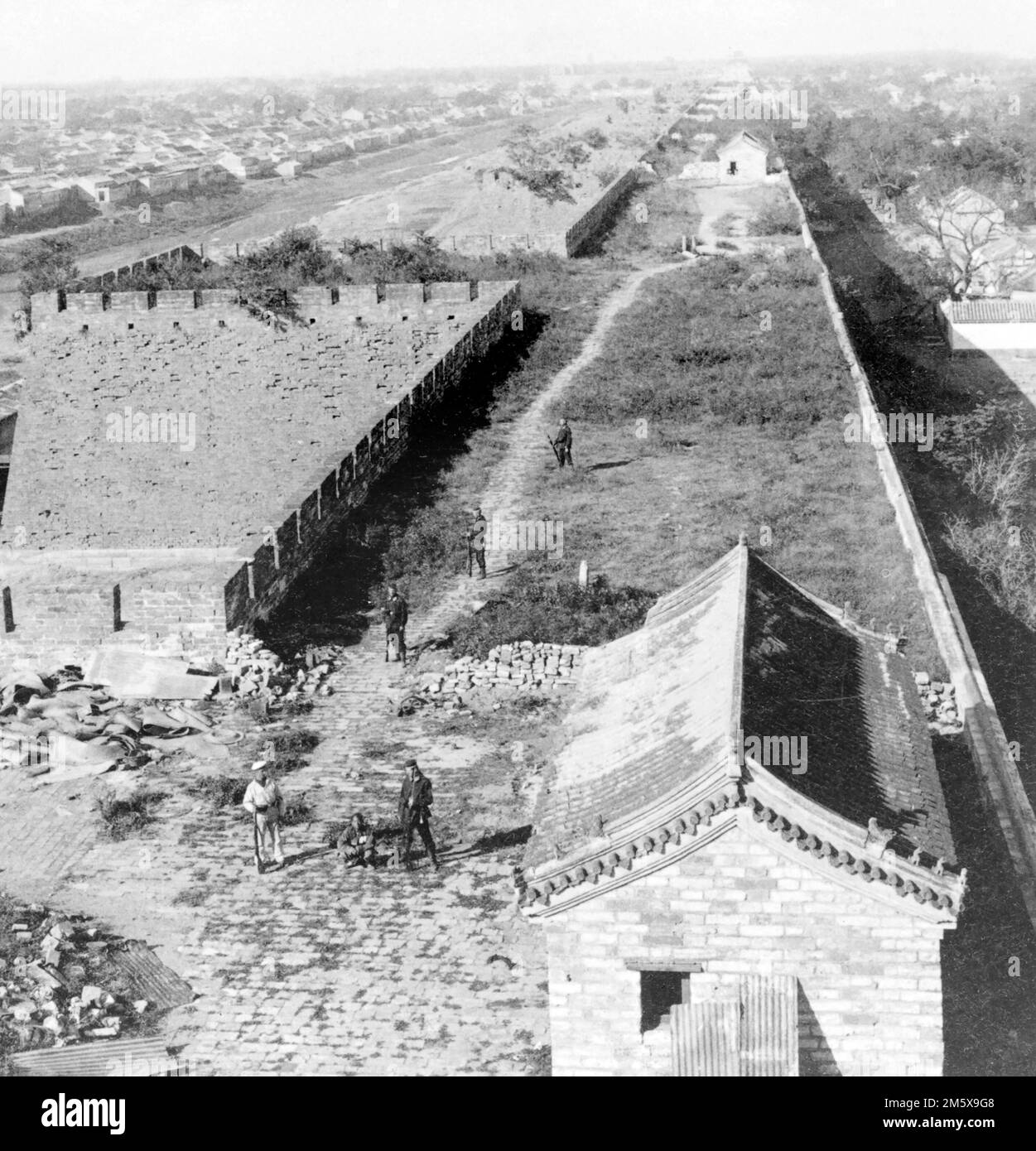 Boxer Rebellion. Looking west from Ha-ta-men Gate along huge ancient wall between Tartar and Chinese Peking, scene of a desperate charge during siege  Photo by Underwood and Underwood, 1900 Stock Photo
