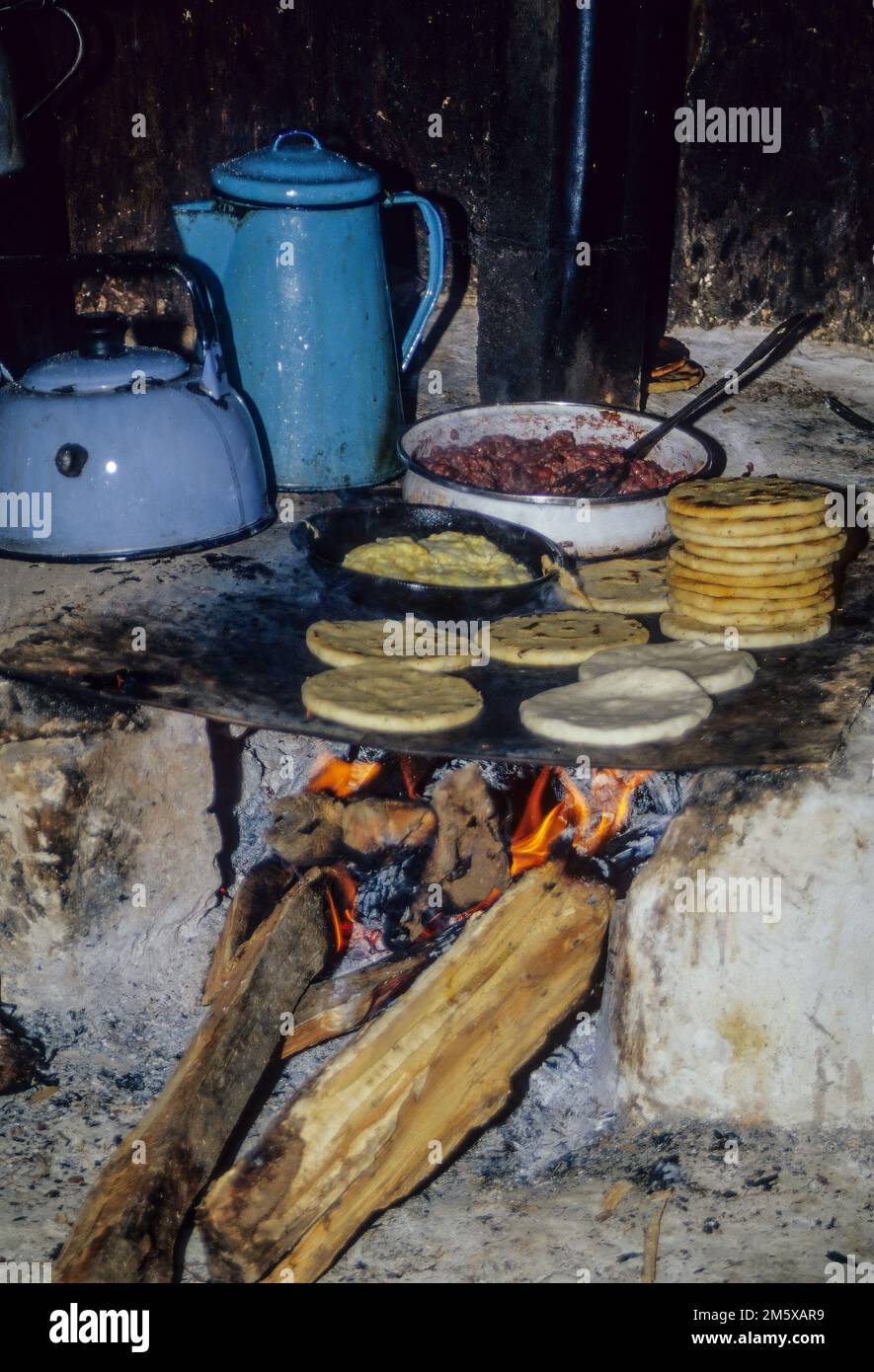 Honduras, San Luis Planes.  Cooking Tortillas over a Wood Fire in a Local Kitchen. Stock Photo