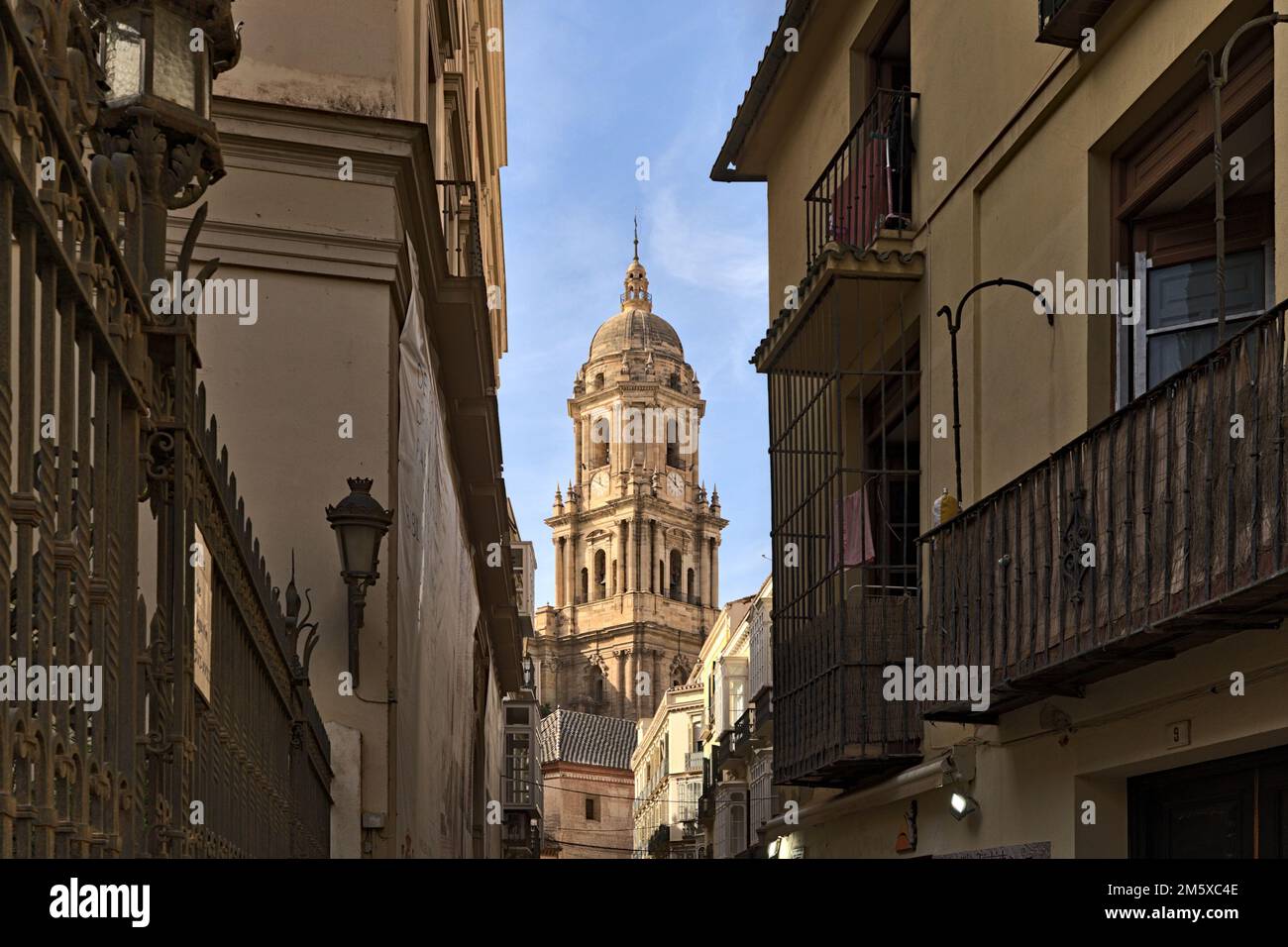 The tower of the Holy Cathedral Church Basilica of the Incarnation, the cathedral of Malaga pictured through a narrow street Stock Photo