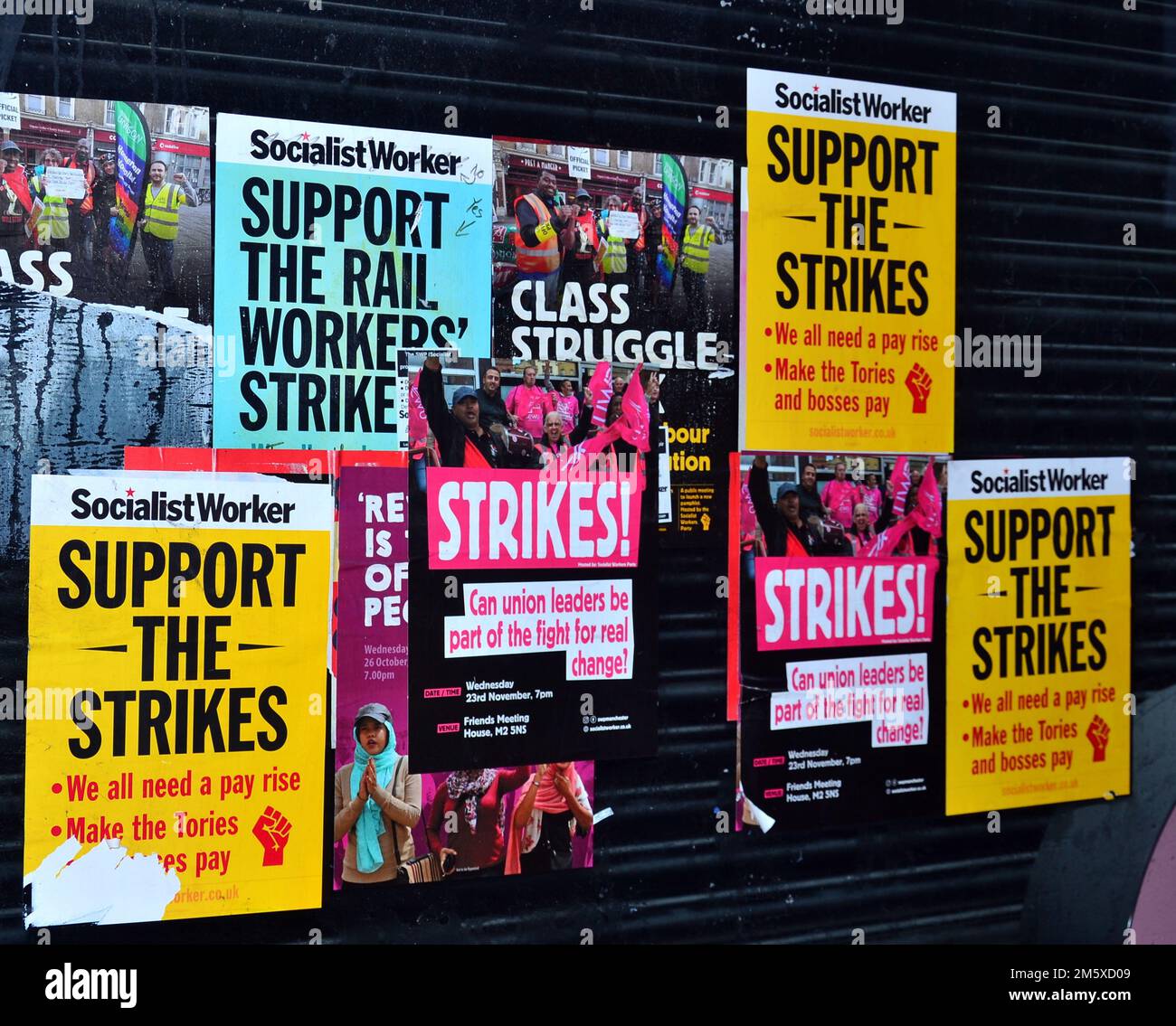 Posters, mainly produced by Socialist Worker, on an empty shop's window in Manchester, UK, urge passers-by to support the strikes. In 2022 there was industrial unrest in the UK as employees in the transport network, NHS, schools, and Royal Mail, took strike action. In 2023 it is expected that there will be stoppages by rail workers, bus drivers, nurses, ambulance workers and  teachers in Scotland. Stock Photo