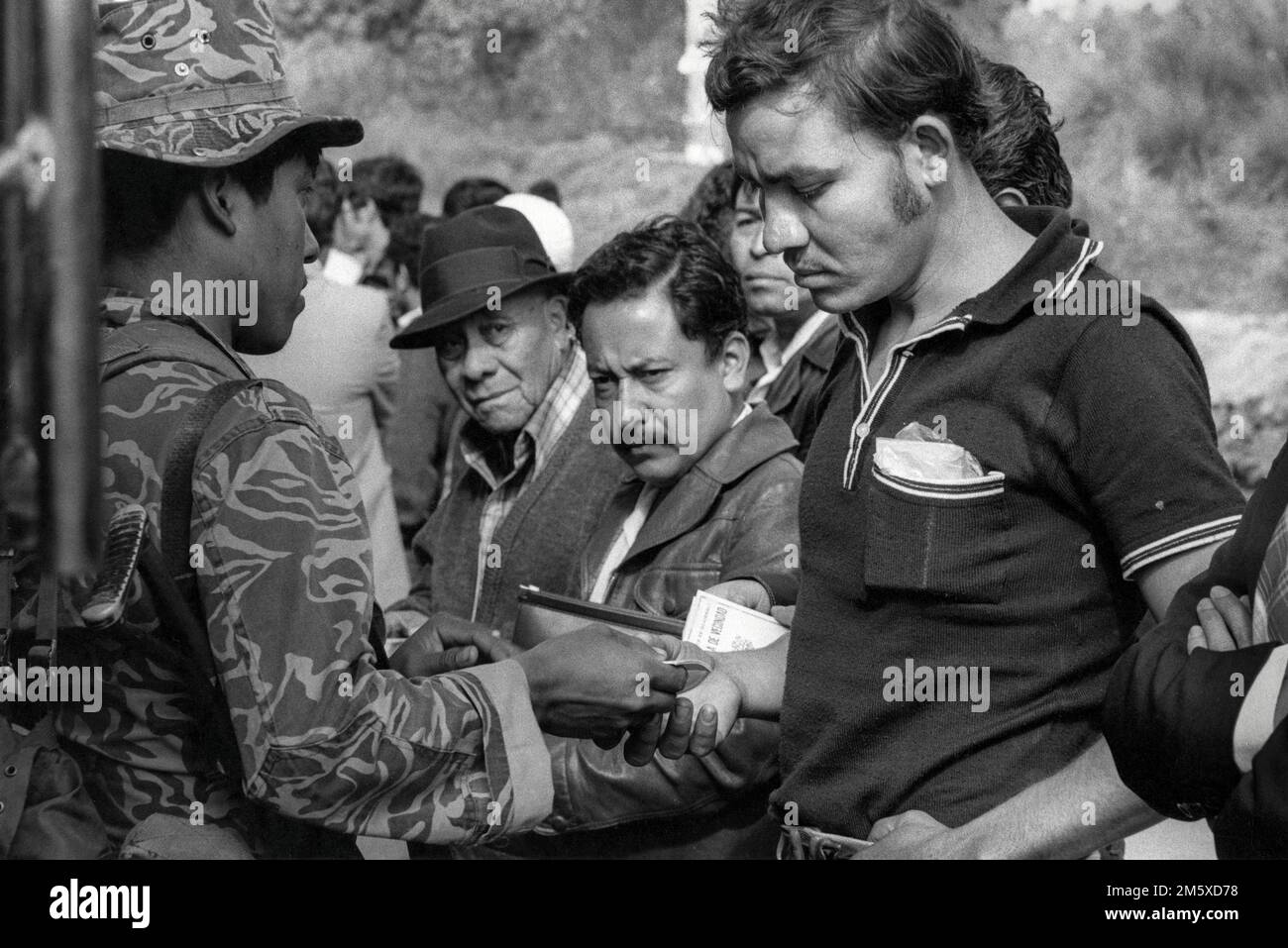 The Guatemalan Army conducting an ID check of bus passengers on the Pan  American Highway as part of a counterinsurgency campaign against leftist guerrilla groups., Guatemala, March 1982. Stock Photo
