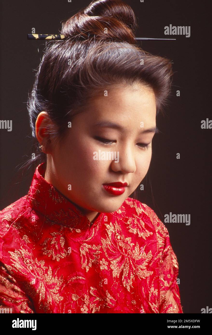 Young Asian woman dressed in a kimono looking pensive glancing downward Stock Photo