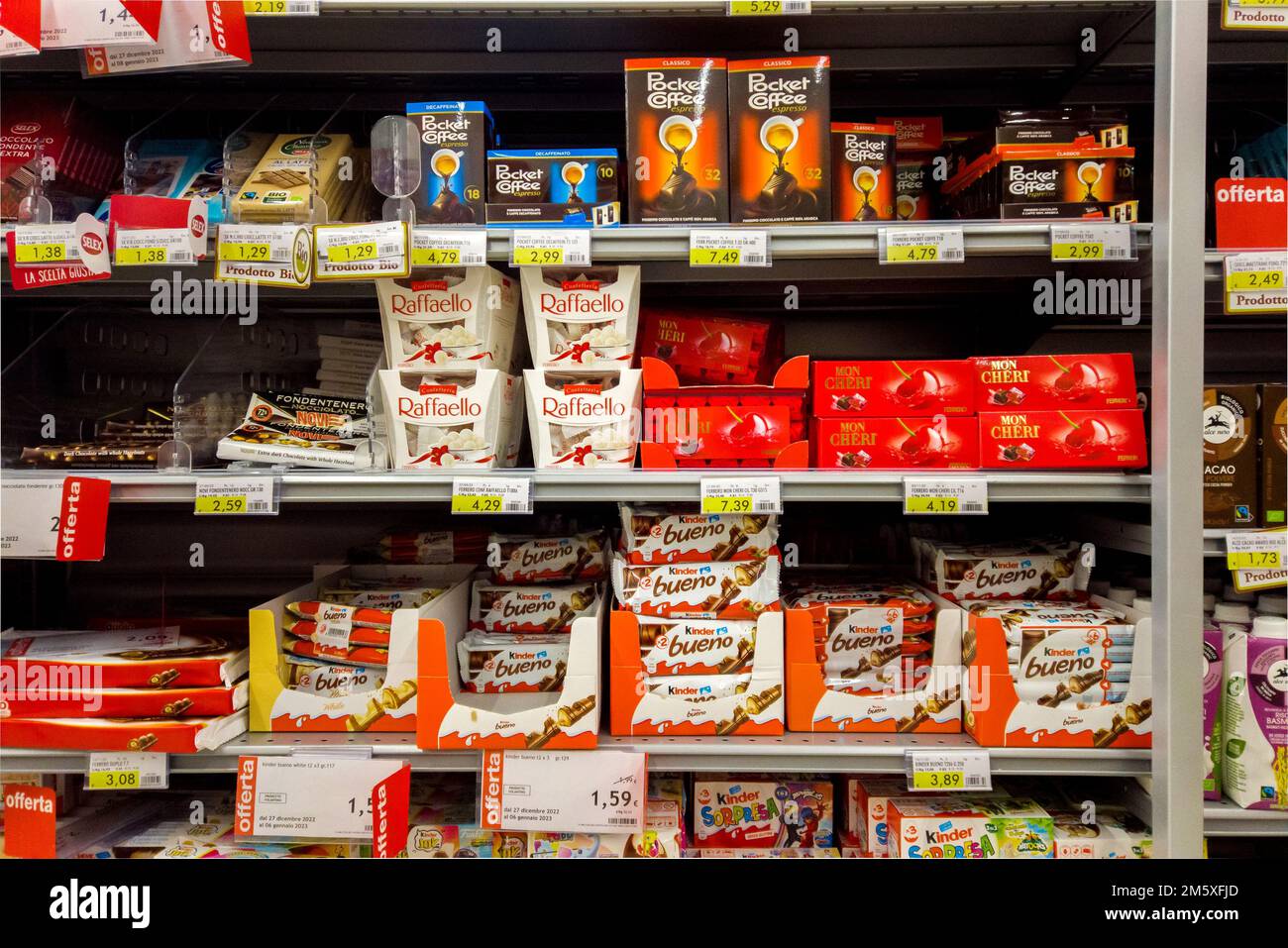 Italy - december 31, 2022: Ferrero chocolates and chocolates on shelf, packs of Pocket Coffee, Raffaello and Kinder Bueno Ferrero displayed for sale i Stock Photo