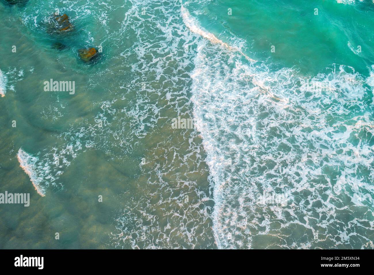 Top view of ocean waves rolling on the beach Stock Photo