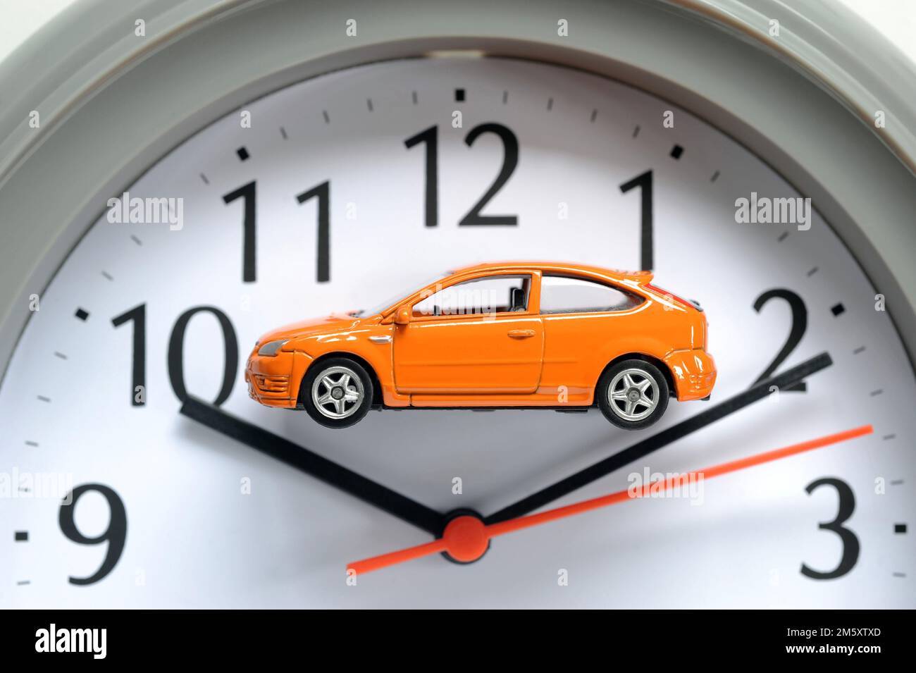 MODEL CAR ON CLOCK FACE RE MOTORISTS CARS ELECTRIC DIESEL PETROL HYBRID SCRAP TIME RUNNING OUT COSTS REPAIRS SECOND HAND CAR BUYERS ETC UK Stock Photo