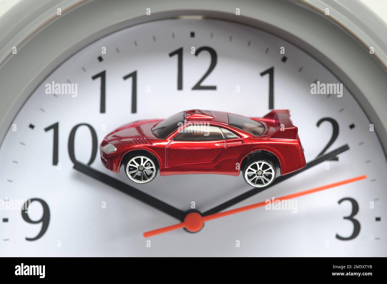 MODEL CAR ON CLOCK FACE RE MOTORISTS CARS ELECTRIC DIESEL PETROL HYBRID SCRAP TIME RUNNING OUT COSTS REPAIRS SECOND HAND CAR BUYERS ETC UK Stock Photo