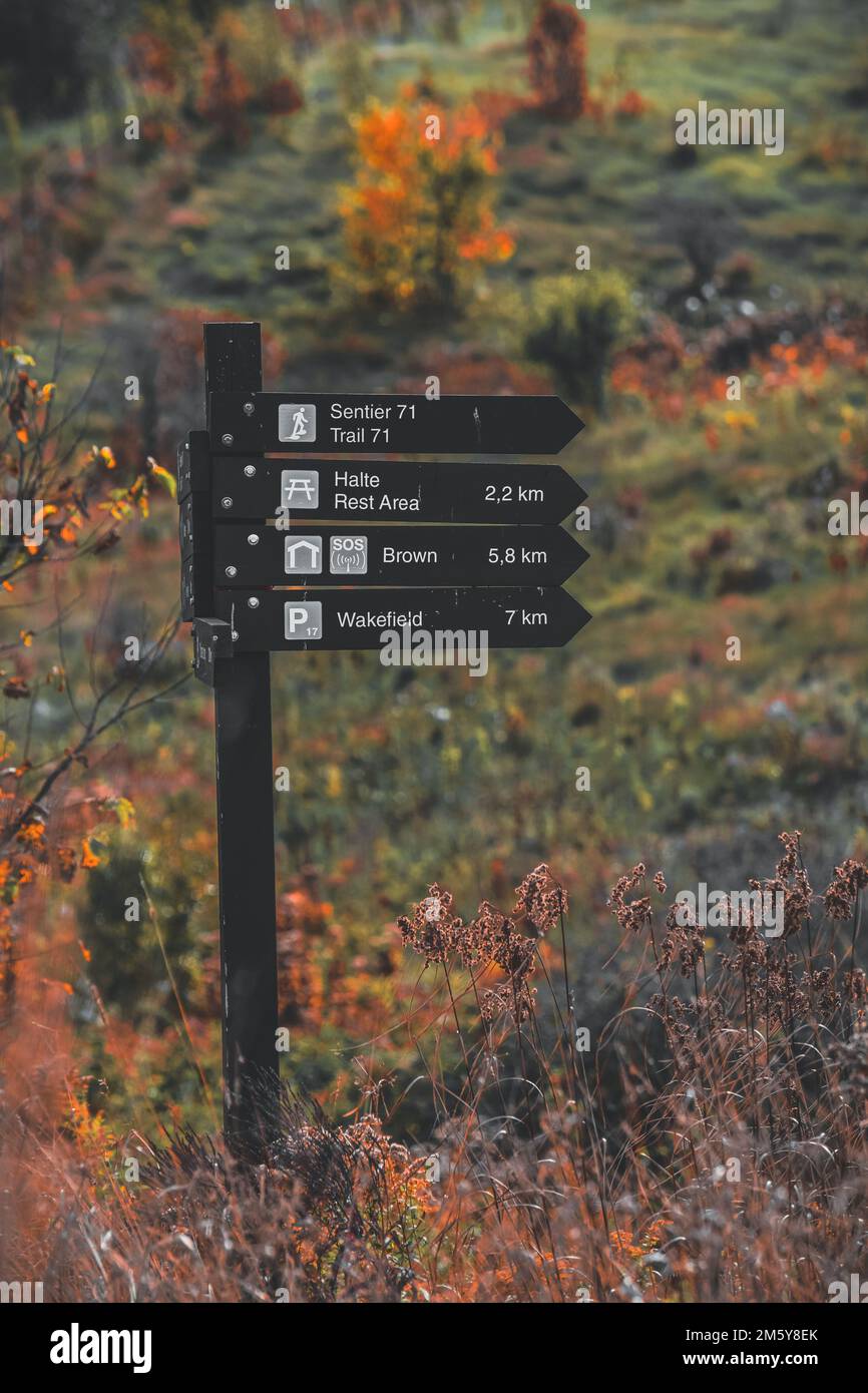 A vertical of a sign post with distances and locations in a hiking ...