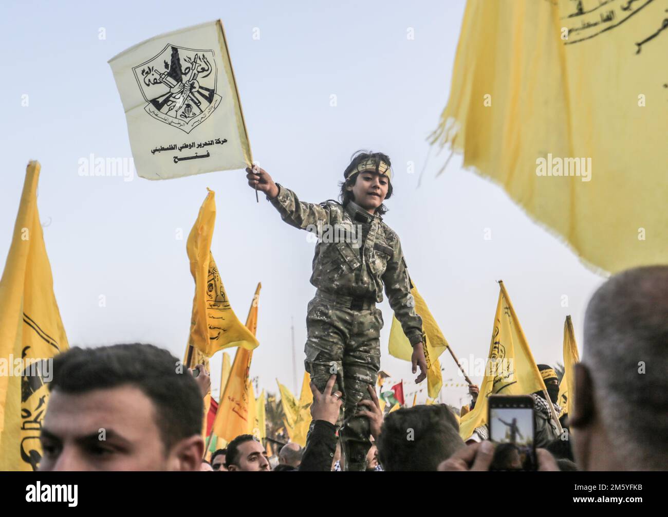A Palestinian child wears a keffiyeh seen waving a flag during the rally to commemorate the 58th anniversary of the founding of the Fatah movement in Gaza City. (Photo by Mahmoud Issa / SOPA Images/Sipa USA) Stock Photo