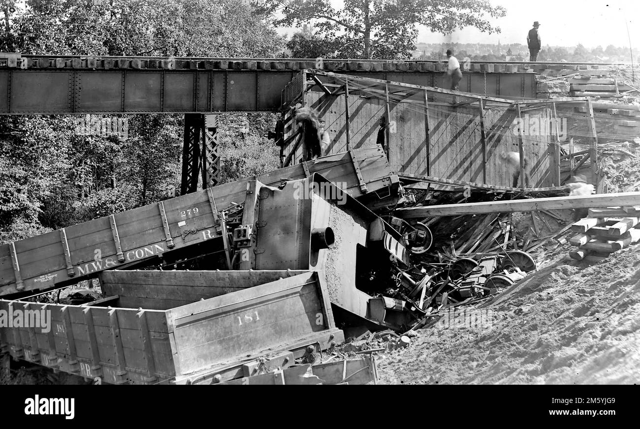 Meriden, Waterbury, and Connecticut River Railroad Train is shown after it has derailed and fallen off a bridge, ca. 1890. Stock Photo