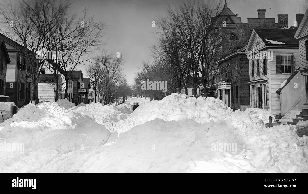 A snowstorm has shut down a Connecticut town street, ca. 1895. The sidewalks are shoveled Stock