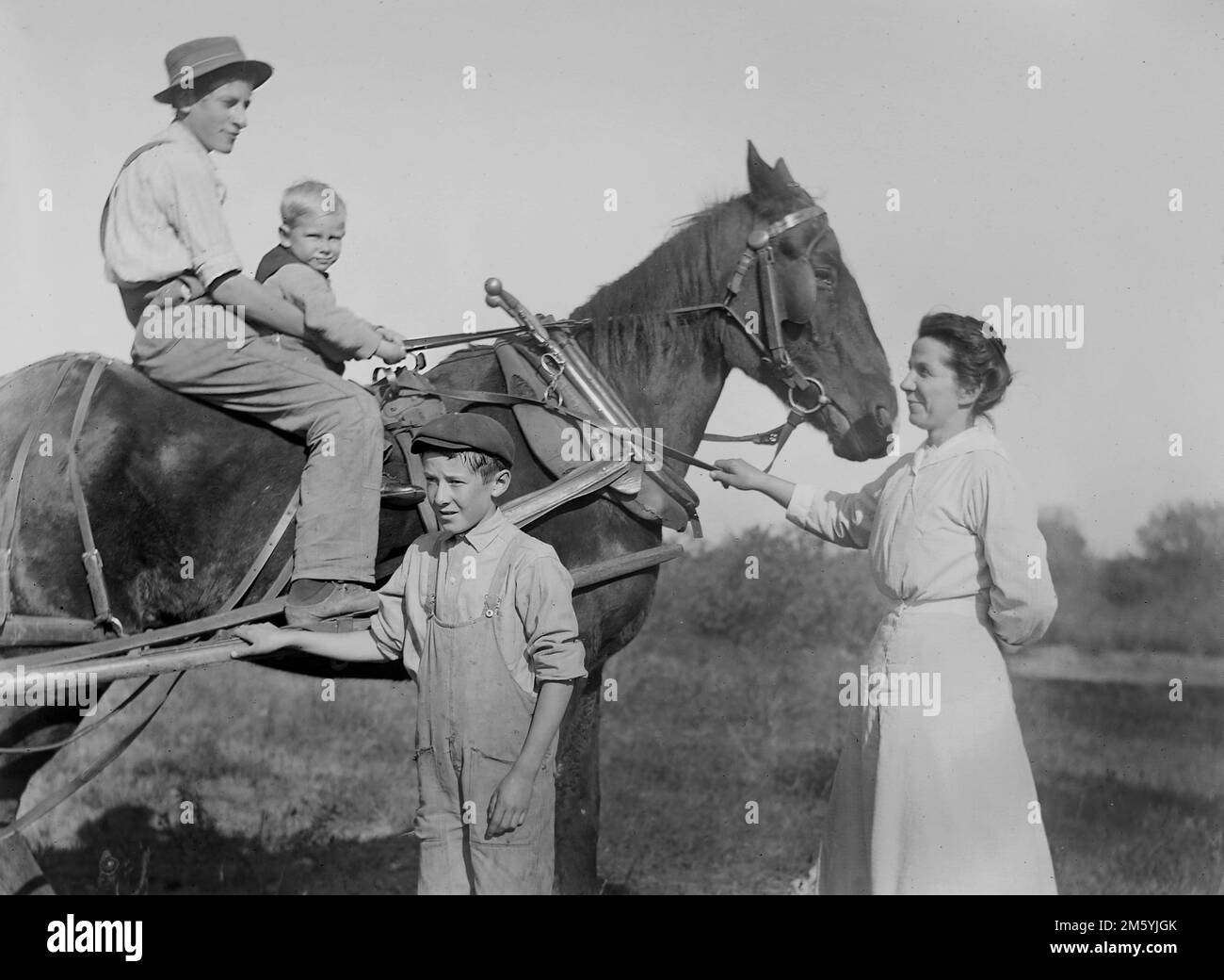 Mom and the children pose with the plow horse on the farm, ca. 1910, Stock Photo