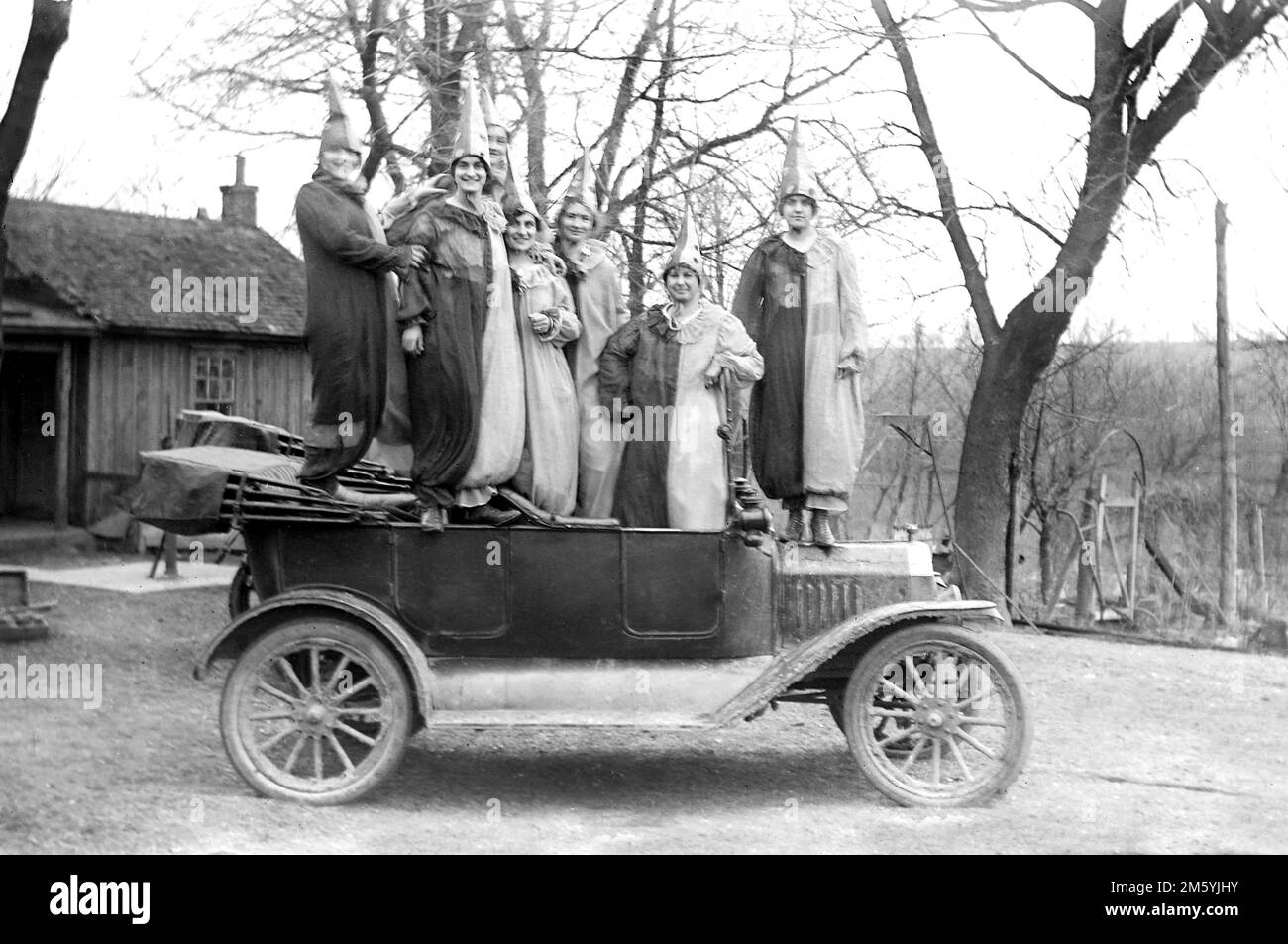 Costumed young people stand on top of their period automobile, ca. 1925. Stock Photo